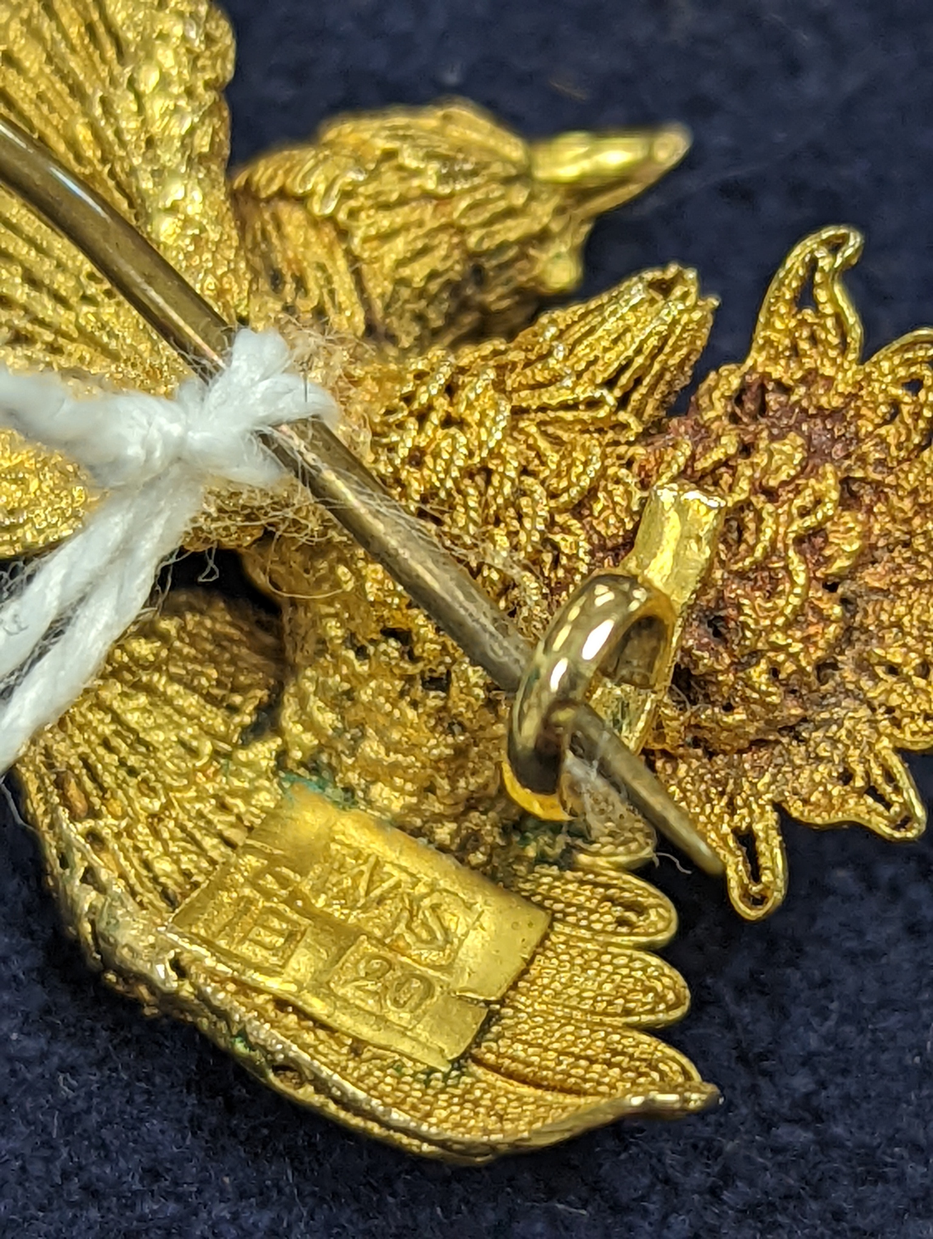 A Chinese filigree yellow metal eagle brooch, stamped 'WS 20 (with character marks)', 36mm, gross 6.5 grams.